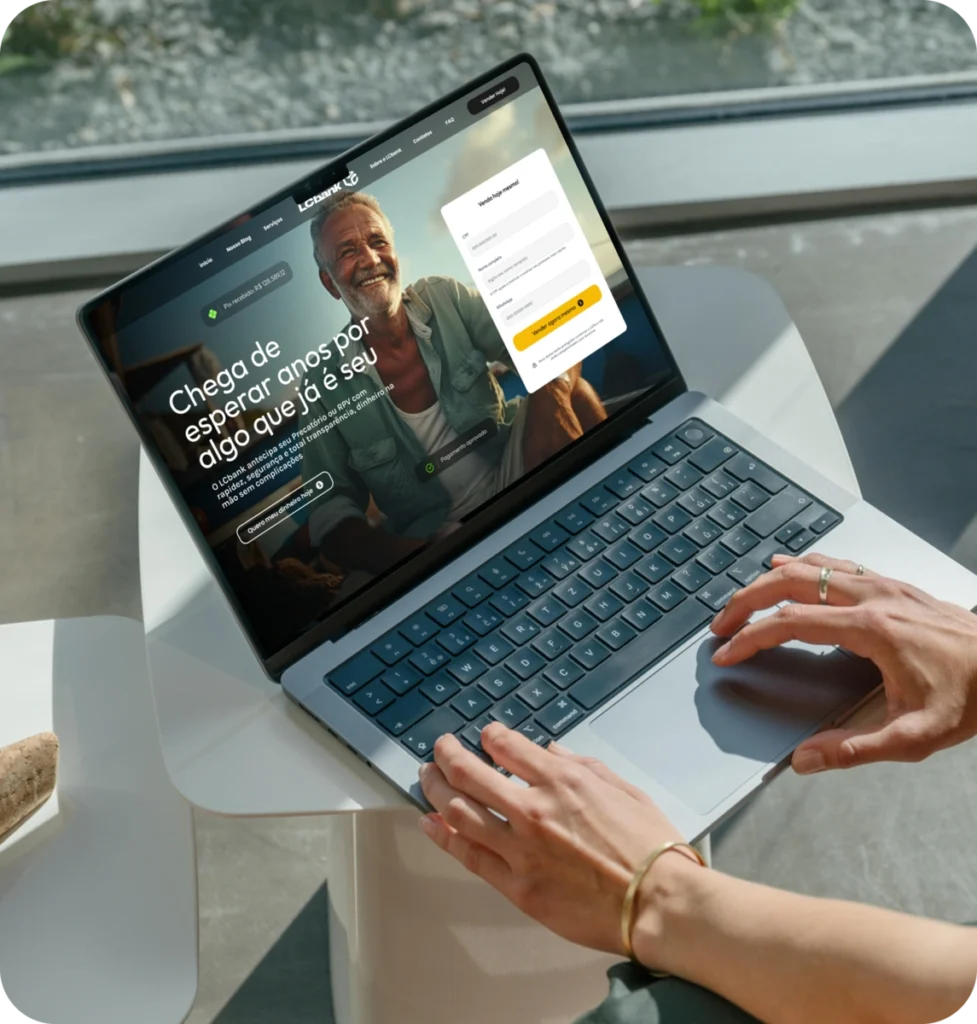 Laptop aberto mostrando site LCbank com login e texto "Chega de esperar anos por algo que já é seu